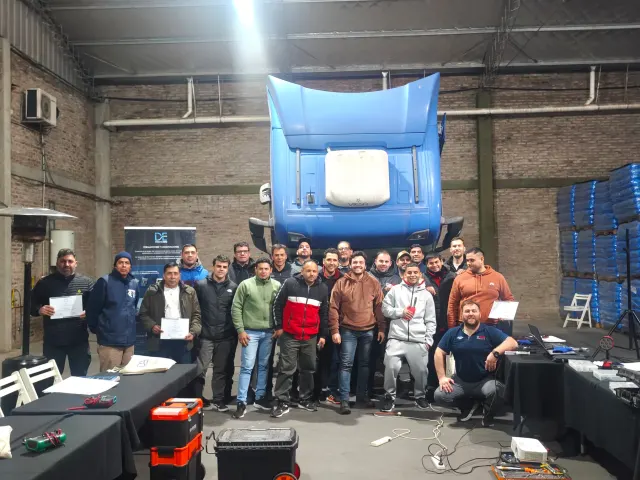 Grupo de participantes del curso Scania en Buenos Aires reunido frente al camión, con certificados visibles