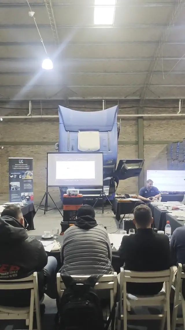 Video de una presentación del curso Scania en Buenos Aires, con participantes, un camión y pantallas
