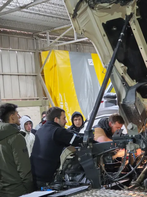 Grupo de participantes realizando una práctica sobre el motor del camión en San Juan